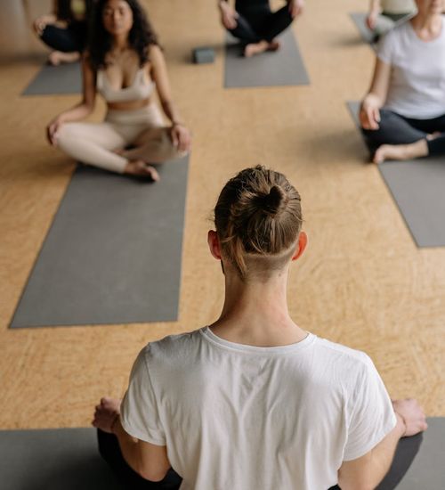 Group of diverse people sitting together on yoga mats.