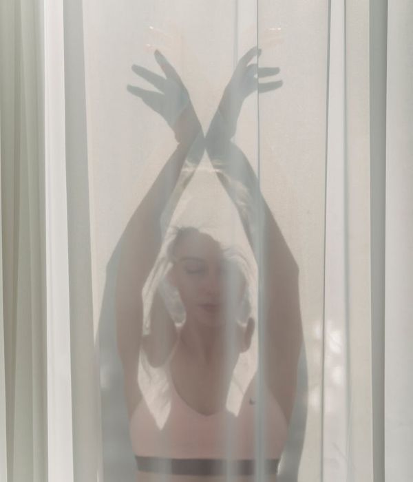 Woman in a graceful morning yoga pose against a light background.